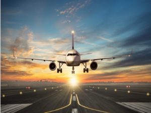 Airplane landing to airport runway in sunset light