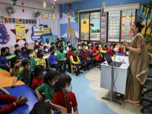 Students wearing protective masks attend a lecture as part of a coronavirus awareness campaign at a school in Kolkata