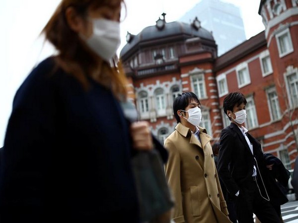 People, wearing protective face masks following an outbreak of the coronavirus disease (COVID-19), are pictured outside Tokyo station in Tokyo