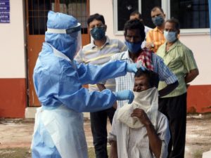 A health worker collects nasal swab samples from a man for COVID-19 test