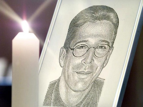 A portrait of the Wall Street Journal's reporter Daniel Pearl stands with a candle at the altar at F..