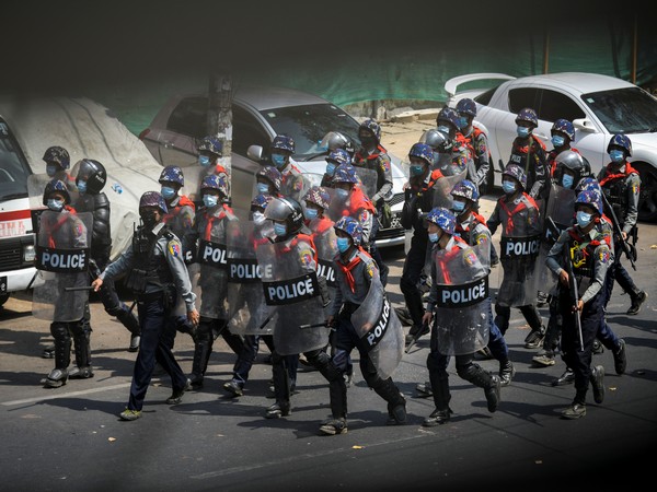 Riot police officers advance on pro-democracy protesters during a rally against the military coup in Yangon