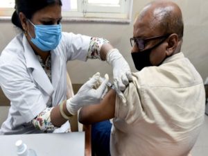 A beneficiary gets a COVID-19 vaccine at Moti Lal Nehru Medical College