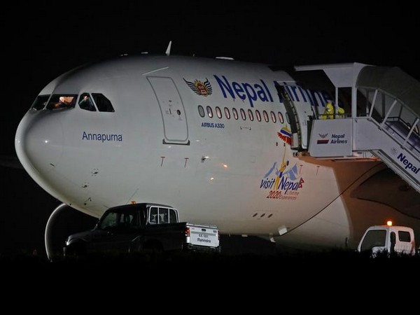 An official in protective suite prepares to evacuate 175 Nepalese nationals from a Nepal Airlines Airbus A330-200 plane arriving from coronavirus-stricken Chinese city of Wuhan before they were sent to be quarantine at Tribhuvan International Airport in Ka