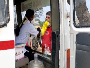 A medic takes a nasal sample of a man for the COVID-19 testing