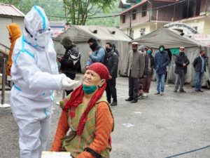 A medic takes a nasal sample of a woman for the COVID-19 testing