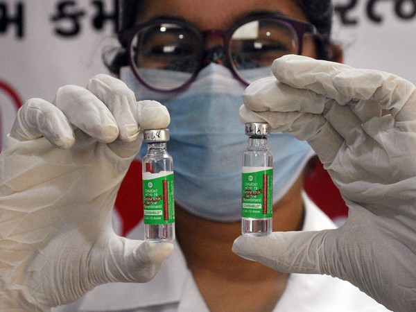 A medic holds COVISHIELD vials