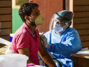 A beneficiary receives a dose of COVID-19 vaccine during a free vaccination drive