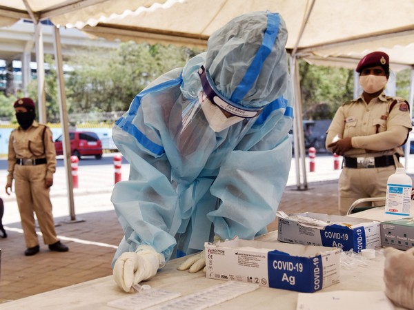 A health worker collects swap samples from COVID suspected people