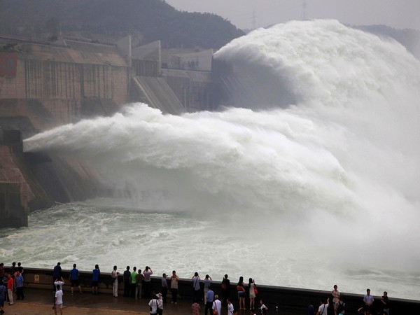 Visitors watch water gushing from the section of the Xiaolangdi Reservoir on the Yellow River, during a sand-washing operation in Jiyuan