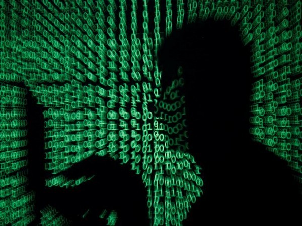 Man holds laptop computer as cyber code is projected on him in this illustration picture