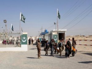 Pakistani soldiers keep guard as citizens return from Afghanistan at the border-crossing town of Chaman