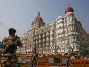 A BSF soldier  takes photographs of his colleague in front of Taj Mahal hotel, which was one of the targets of the Mumbai 2008 attacks, which killed 166 people, in Mumbai