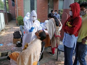 Medical staff collects swab samples of the people during random testing for COVID-19