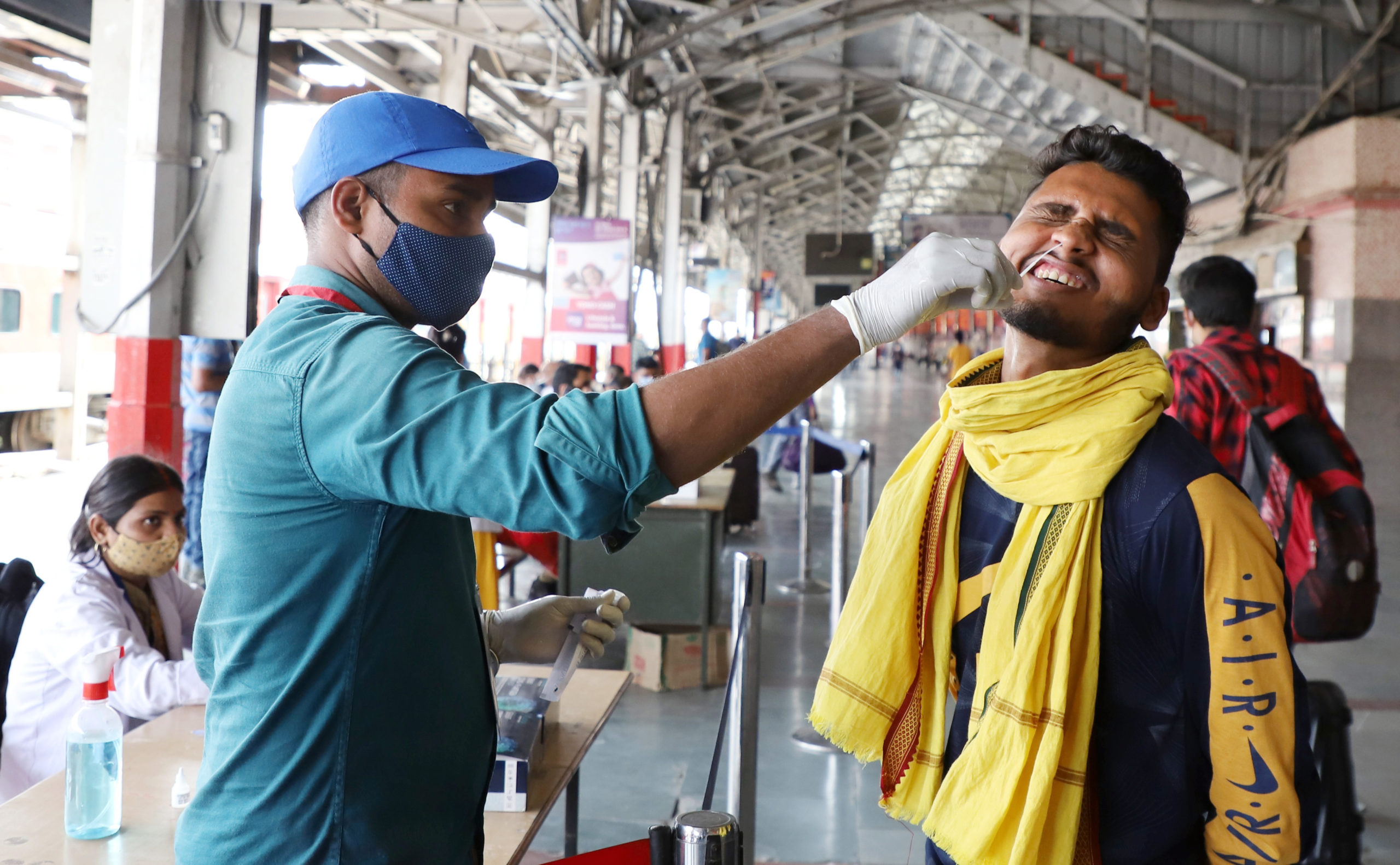 Health worker collects a nasal sample from a passenger