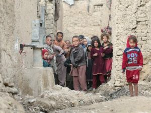 Internally displaced Afghan children looking on next to their shelters on the outskirts of Kabul