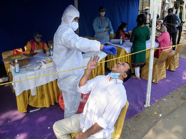 A health worker collects swab sample from people for RT-PCR COVID-19 test