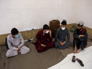 Afghan nationals sit at an Afghan refugee camp in Zahedan