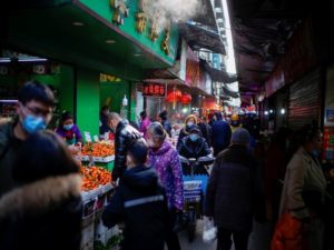 People wearing face masks walk on a street market, following an outbreak of the coronavirus disease (COVID-19) in Wuhan