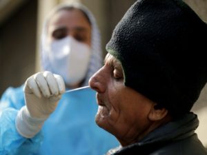 A healthcare worker collects a swab sample for COVID-19 test