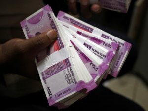 FILE PHOTO: A cashier displays the new 2000 Indian rupee banknotes inside a bank in Jammu