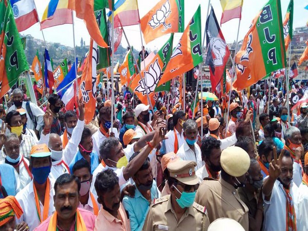 BJP supporters carry party flag during the roadshow of Defence Minister Rajnath Singh