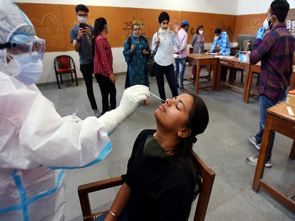 health worker collects a nasal swab sample from students for the Covid-19 coronavirus