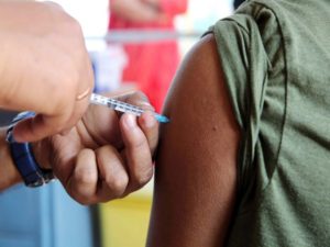 A beneficiary receives a dose of the COVID-19 vaccine during a vaccination drive