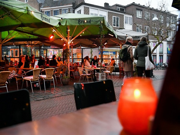 Visitors are seen outside a bar which may open again after a lockdown