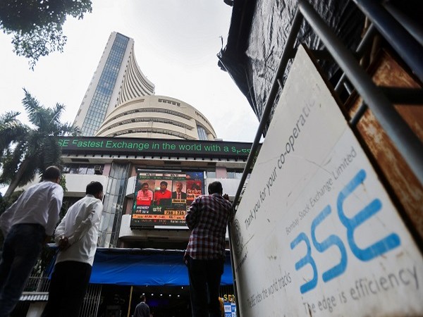 People stand outside the Bombay Stock Exchange (BSE), after Sensex surpassed the 60,000 level for the first time, in Mumbai