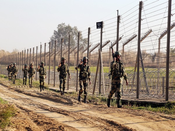 Border Security Force (BSF) soldiers patrol  India-Pakistan border fencing ahead of Republic day celebration