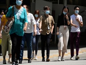 People wearing face masks cross a road, amid the coronavirus disease (COVID-19) Omicron wave in Singapore