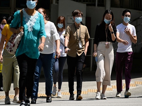 People wearing face masks cross a road, amid the coronavirus disease (COVID-19) Omicron wave in Singapore