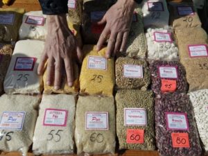 Vendor sorts packs of grains displayed for sale at food market in Stavropol