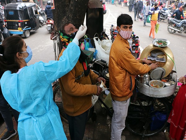 A healthcare worker collects a nasal swab sample from a vendor