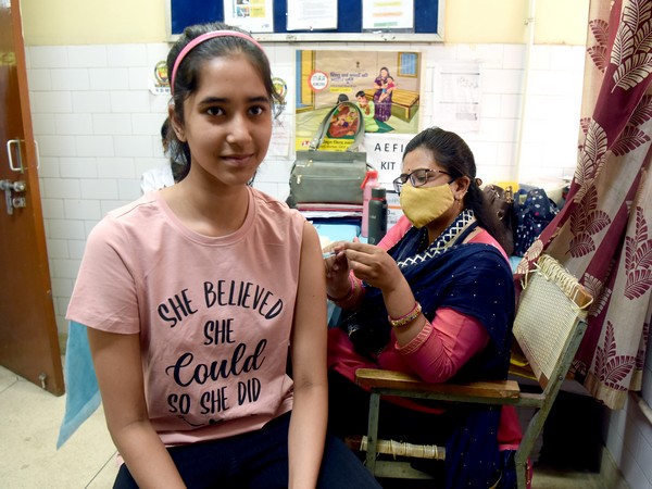 A healthcare worker administers a dose of COVID-19 vaccine