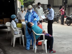 Medical staff collects the swab samples from people for COVID-19 testing at Clinic on Wheels