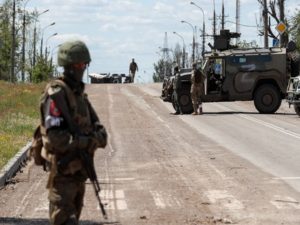 Service members of pro-Russian troops stand guard in Mariupol