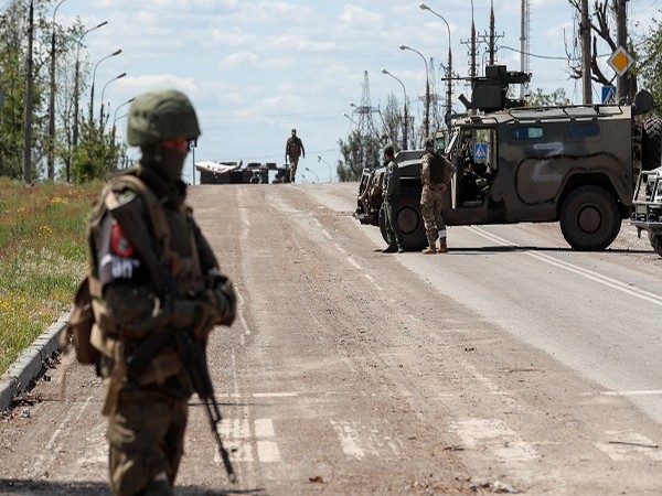 Service members of pro-Russian troops stand guard in Mariupol