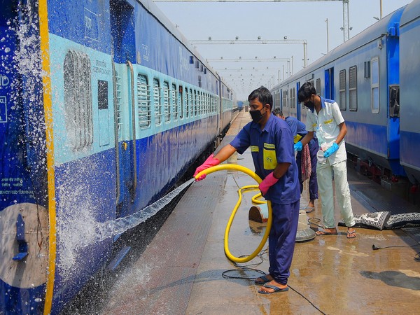 Workers cleaning the railway cabins as a train coach converted into an isolation ward for COVID-19 patients