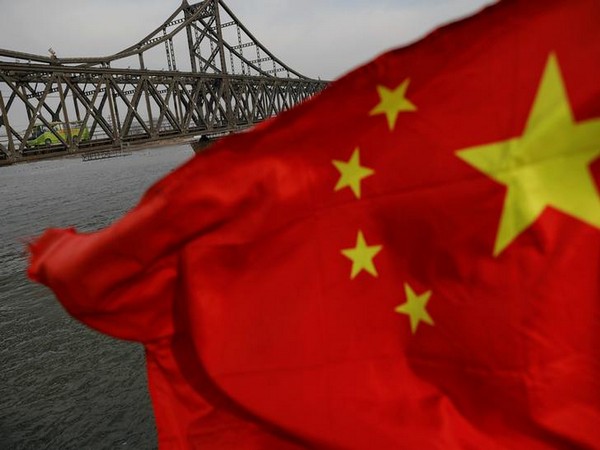 A Chinese flag is seen in front of the Friendship bridge over the Yalu River connecting the North Korean town of Sinuiju and Dandong in China's Liaoning Province