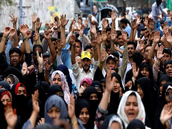 Pakistani Shi'ite people rise their hands as they chant slogans to condemn the Friday's blast at vegetable market in Quetta, during a protest in Karachi,