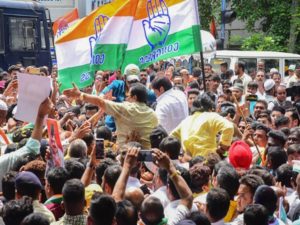 Congress workers and supporters hold party flags celebrate the party's victory