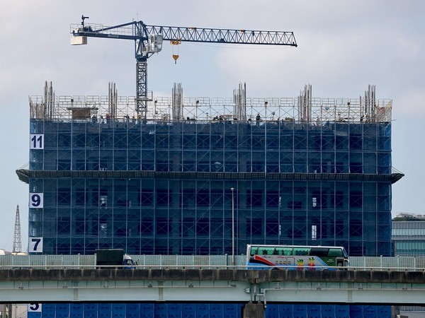 Bus drives past building under construction in Taipei