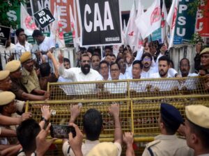 Police personnel stand guard as North-East Students Organisation (NESO) leaders and supporters stage a protest